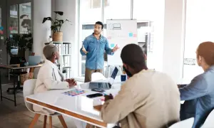 Zespół korporacji dyskutuje strategię marketingową przy tablicy.