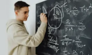 Chłopak pisze wzory matematyczne na tablicy. Czy to przedmioty, jakie odchodzą w 4 klasie liceum?