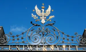 Złoty orzeł na bramie uniwersytetu, symbol dumy i osiągnięć, jak dyplom ukończenia studiów.