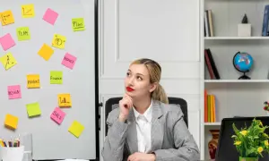 Kobieta w biurze z tablicą pełną karteczek samoprzylepnych z hasłami marketingowymi.