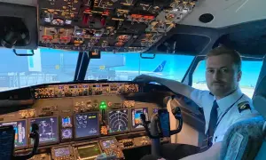 Młody pilot w kabinie samolotu, gotowy do lotu. Chcesz wiedzieć, jak zostać pilotem? To zdjęcie pokazuje początek tej fascynującej drogi.
