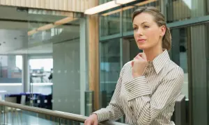 Kobieta w eleganckiej koszuli, zastanawiająca się nad strategią firmy. Czy to przyszły ceo?