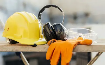 Żółty kask, słuchawki, okulary i rękawice. Podstawa bezpieczeństwa i higieny pracy na budowie.