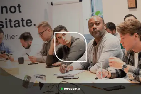 Uczestnicy podczas sesji assessment center, skupieni na zadaniach przy stole.