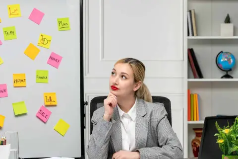 Kobieta w biurze z tablicą pełną karteczek samoprzylepnych z hasłami marketingowymi.