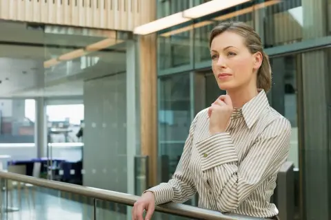 Kobieta w eleganckiej koszuli, zastanawiająca się nad strategią firmy. Czy to przyszły ceo?