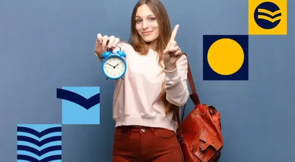 Młoda kobieta z plecakiem trzyma budzik, wskazując palcem. Czas na świadectwo dojrzałości!