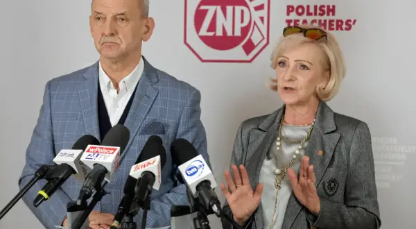 Dwoje przedstawicieli ZNP, związku zawodowego nauczycieli, podczas konferencji prasowej. Mężczyzna w kratę, kobieta w szarym żakiecie.