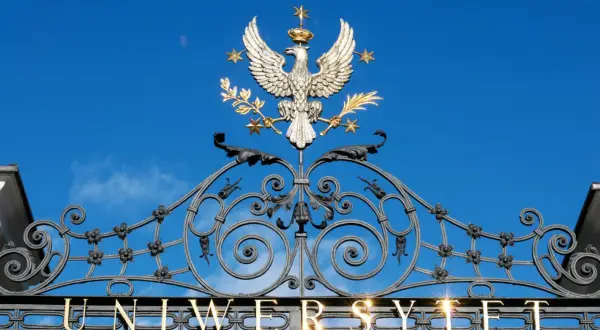 Złoty orzeł na bramie uniwersytetu, symbol dumy i osiągnięć, jak dyplom ukończenia studiów.