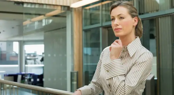 Kobieta w eleganckiej koszuli, zastanawiająca się nad strategią firmy. Czy to przyszły ceo?