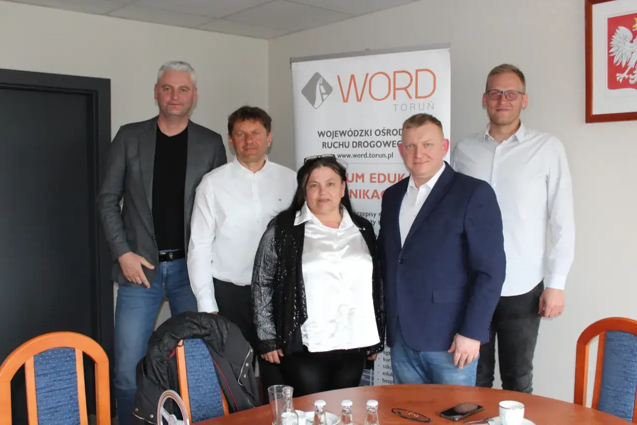 Grupa osób pozuje do zdjęcia podczas kursu na instruktora nauki jazdy w WORD Toruń.