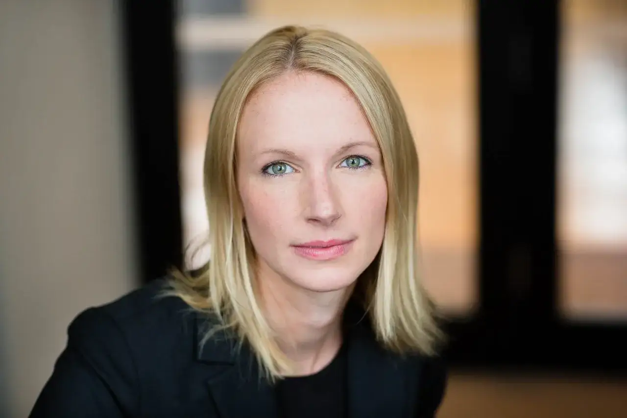 Portret kobiety z blond włosami, w czarnej marynarce. Idealne zdjęcie do CV zrobione telefonem.