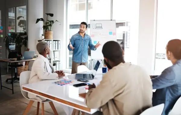 Zespół korporacji dyskutuje strategię marketingową przy tablicy.