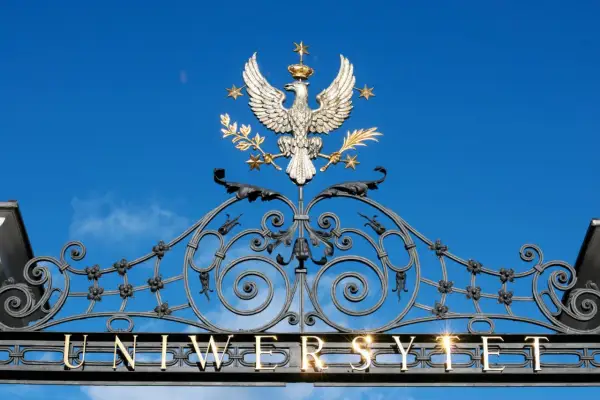 Złoty orzeł na bramie uniwersytetu, symbol dumy i osiągnięć, jak dyplom ukończenia studiów.